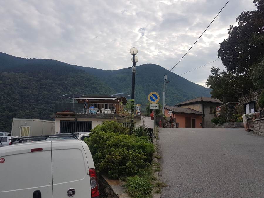 A narrow street in a village in the Valle Cannobina under a cloudy sky