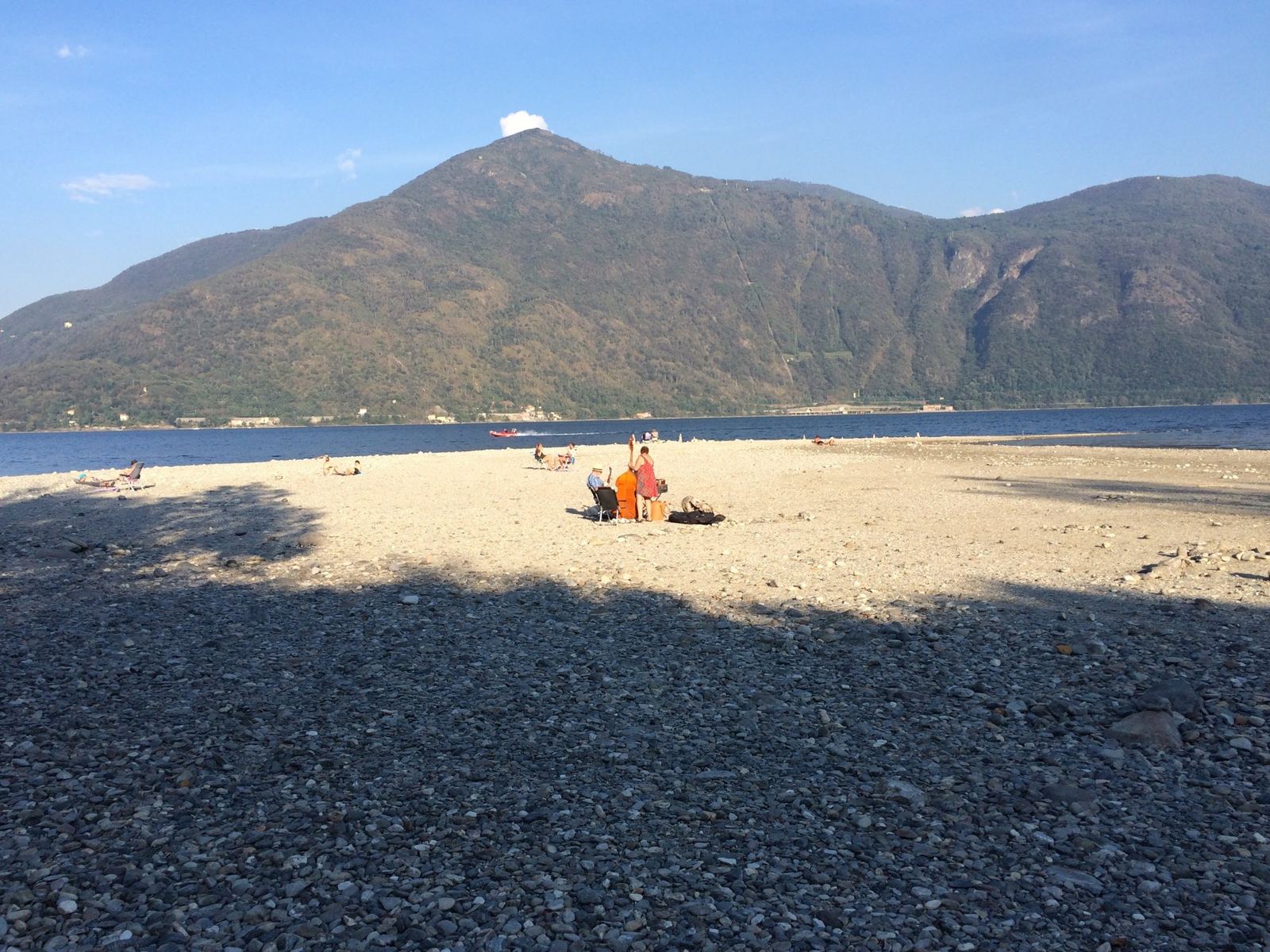 The pebble beach at Cannobio with Lake Maggiore and a mountain across the water
