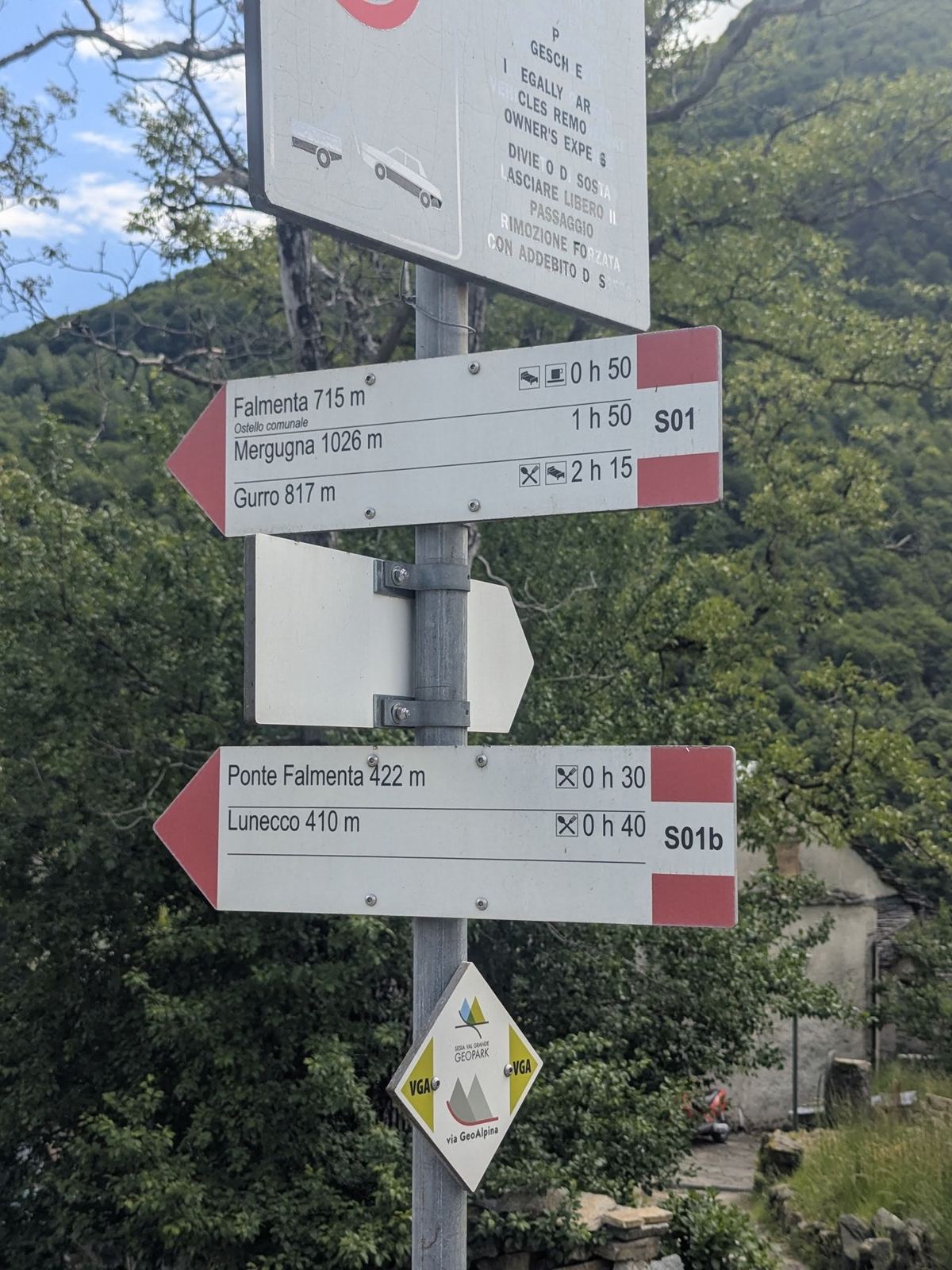 Red-and-white walking signposts in Crealla pointing to Falmenta, Lunecco and other villages