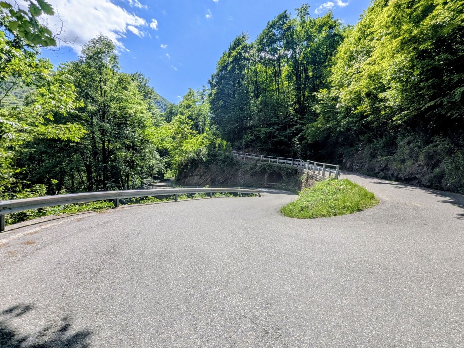 A sweeping hairpin bend on the road down from Falmenta through green woods
