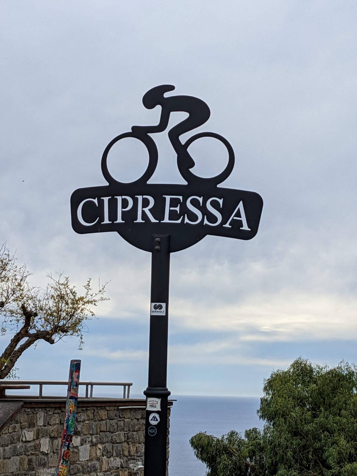 The road sign for Cipressa with a cycle-route marker underneath