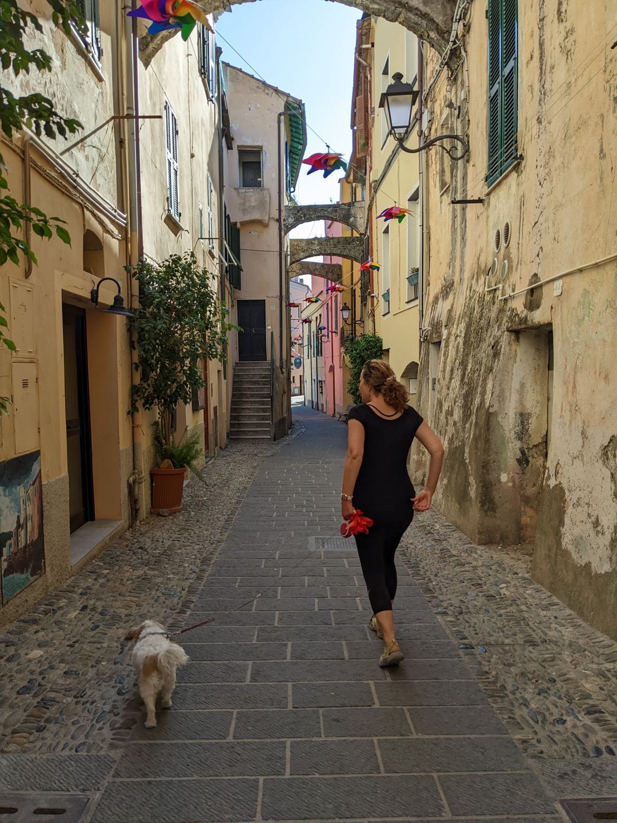 My wife and our dog Lillie walking down a narrow old-town lane in Santo Stefano al Mare