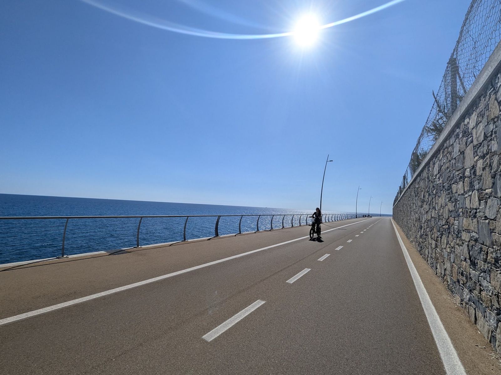 The new cycle path running along a high stone wall beside the sea