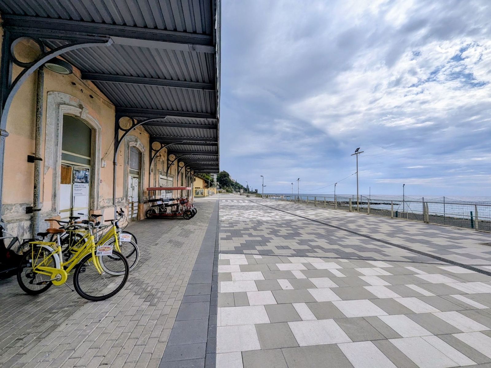 Yellow hire bikes parked under the platform roof of an old railway station on the coast path