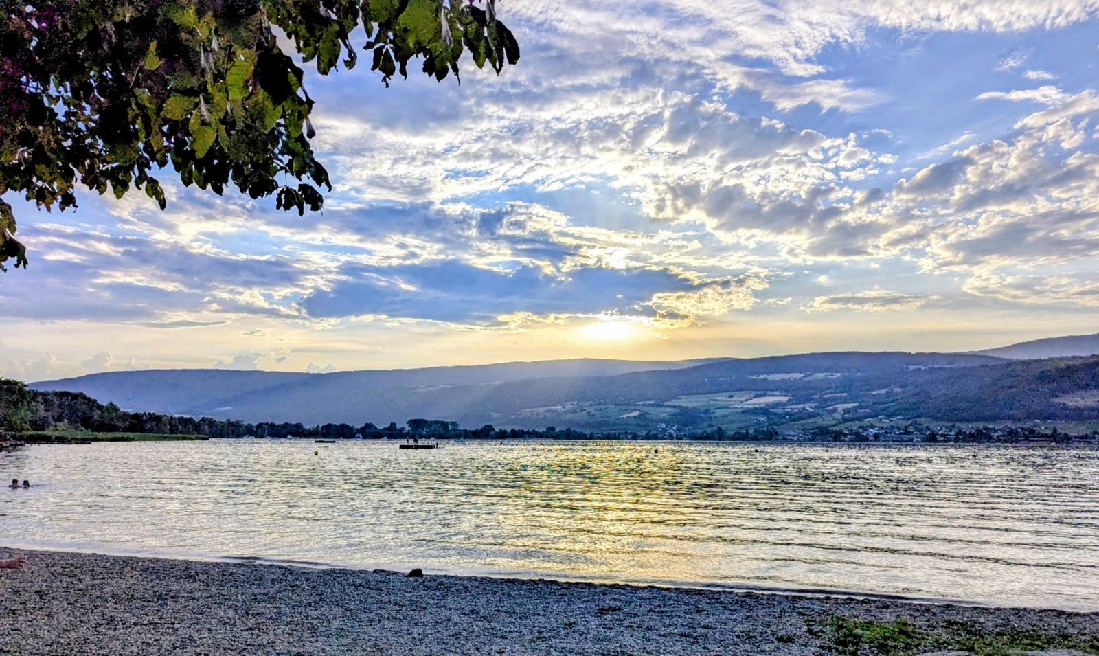 The sun setting over Lake Biel from the pebble beach at Erlach, under a big sky of cloud