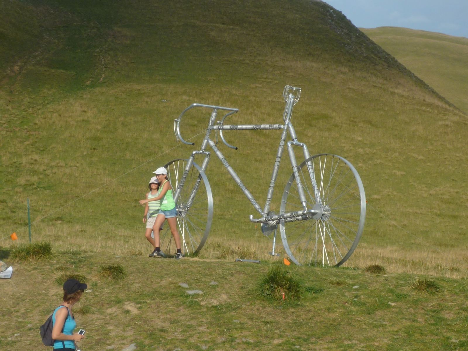 A giant metal bicycle sculpture on a grassy hillside by the Glandon road
