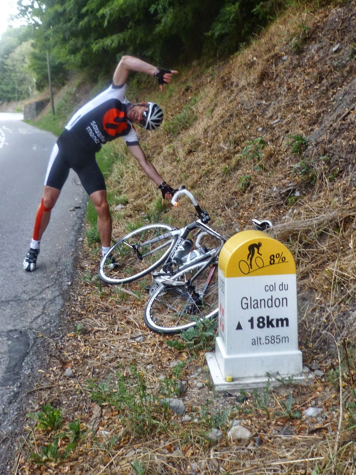 A Col du Glandon kilometre marker by the road with a bike