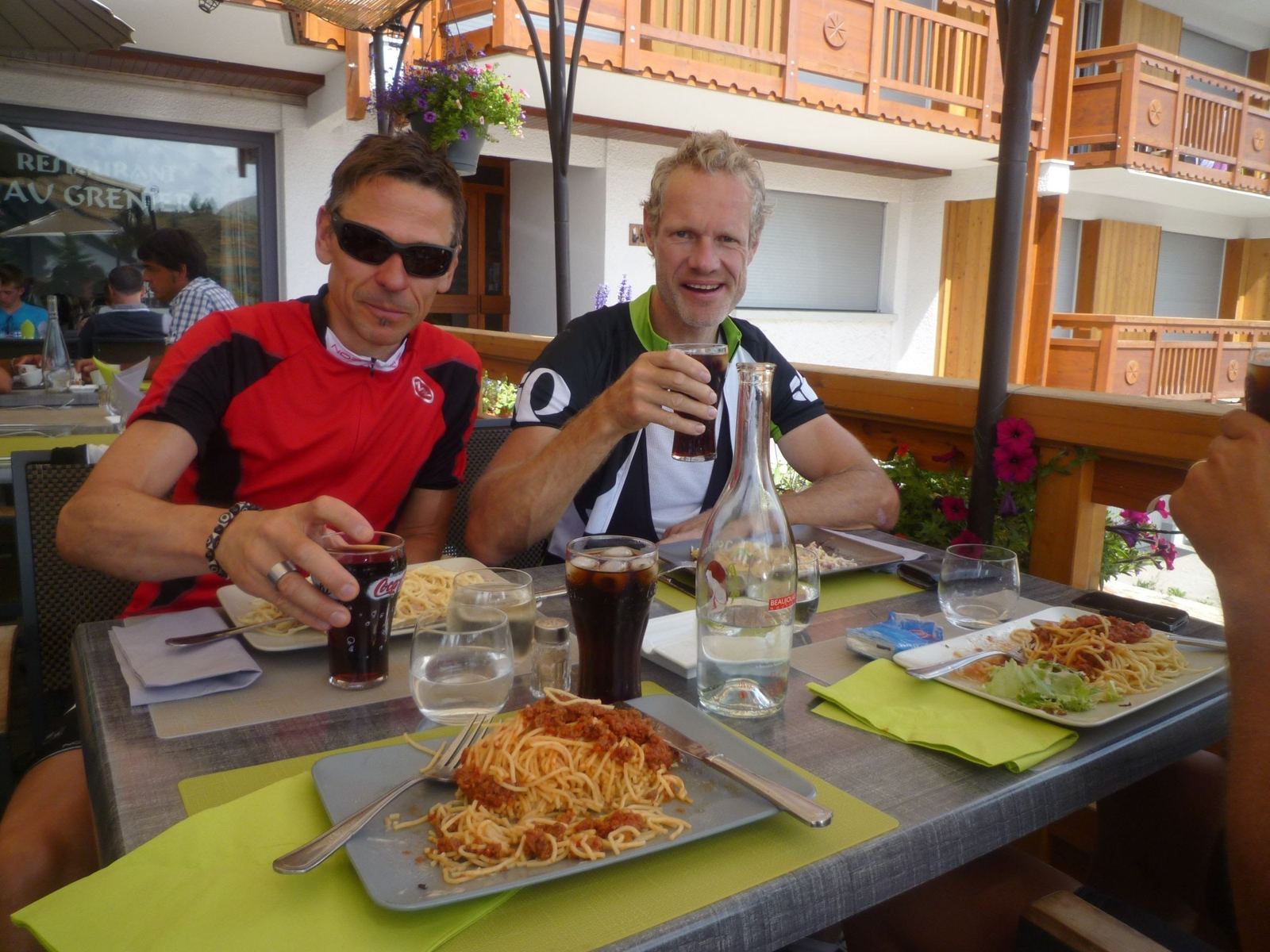 Three cyclists at lunch on a terrace at Alpe d'Huez
