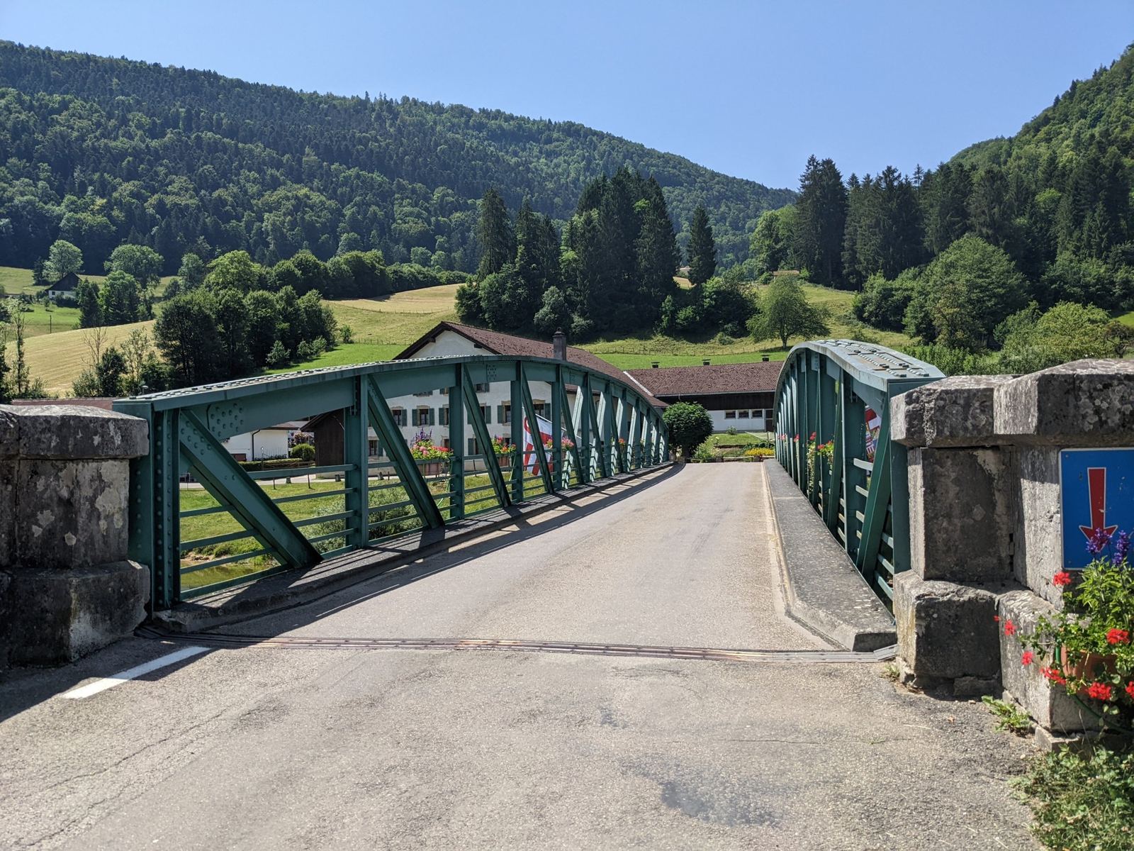 A green iron girder bridge carrying the road over the Doubs at Soubey