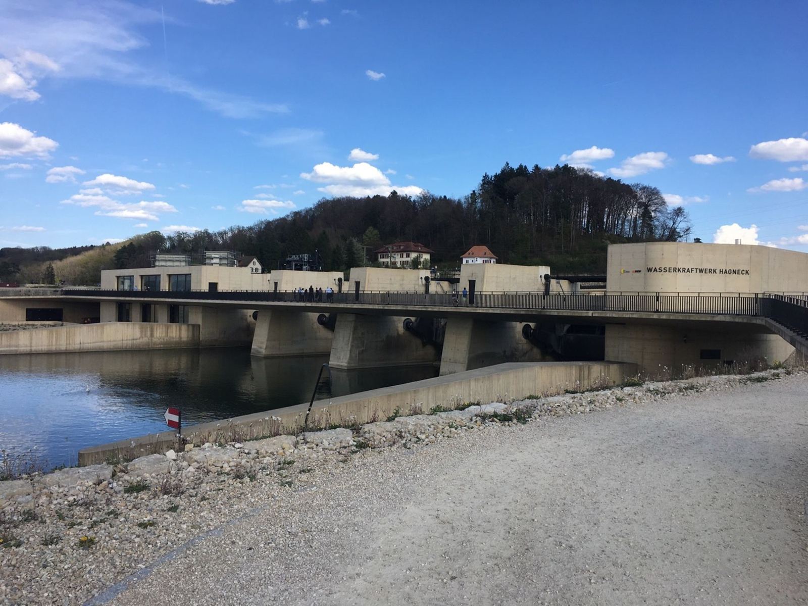 The concrete hydroelectric power station across the Aare canal at Hagneck, with a wooded hill behind