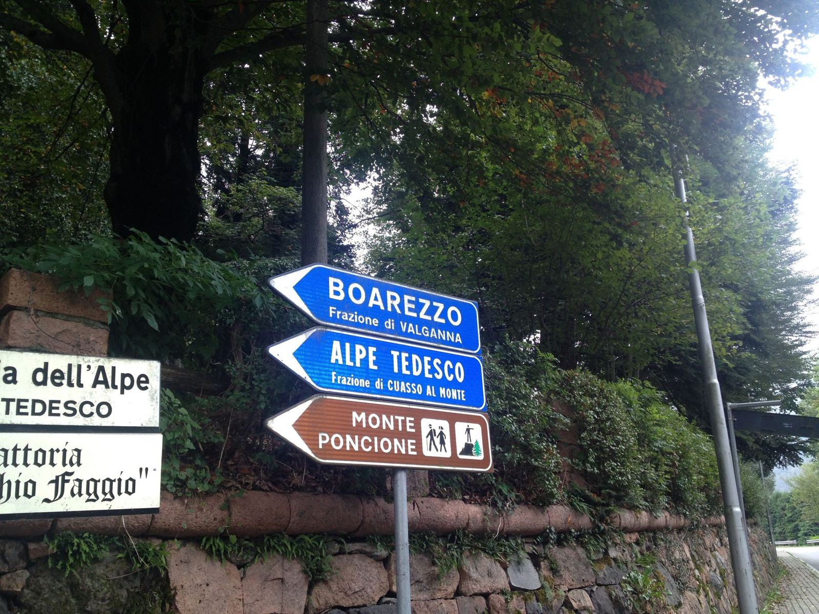 Blue road signs for Boarezzo and Alpe Tedesco and a brown sign for Monte Poncione