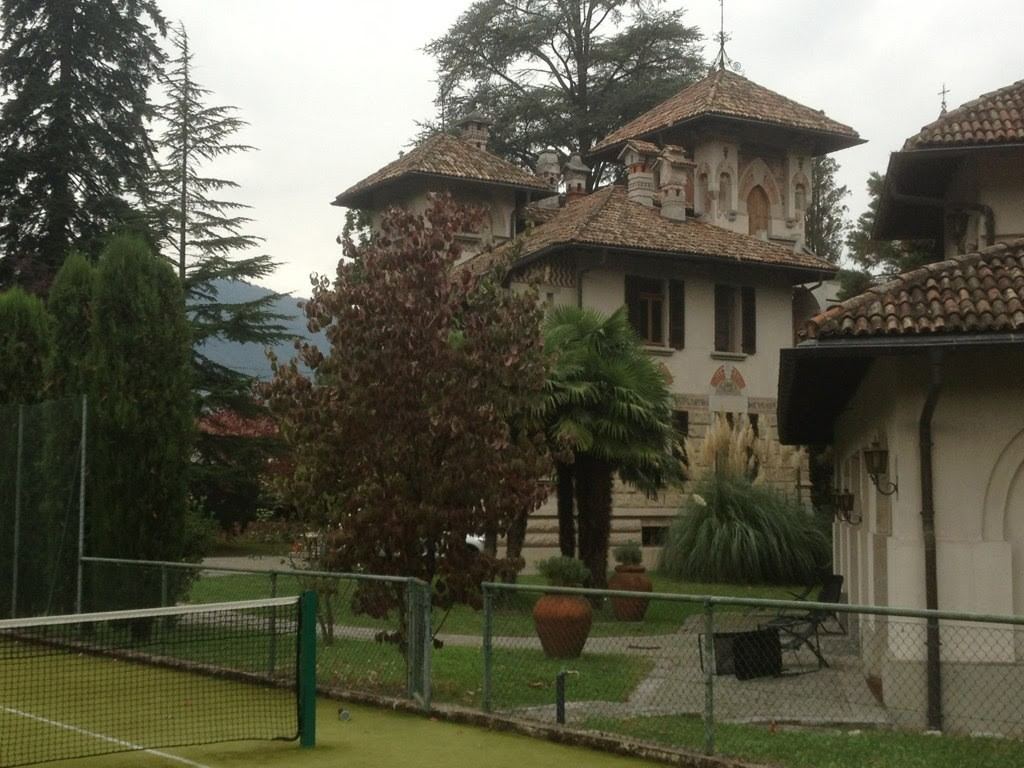 An old villa among palm trees beside Lake Lugano