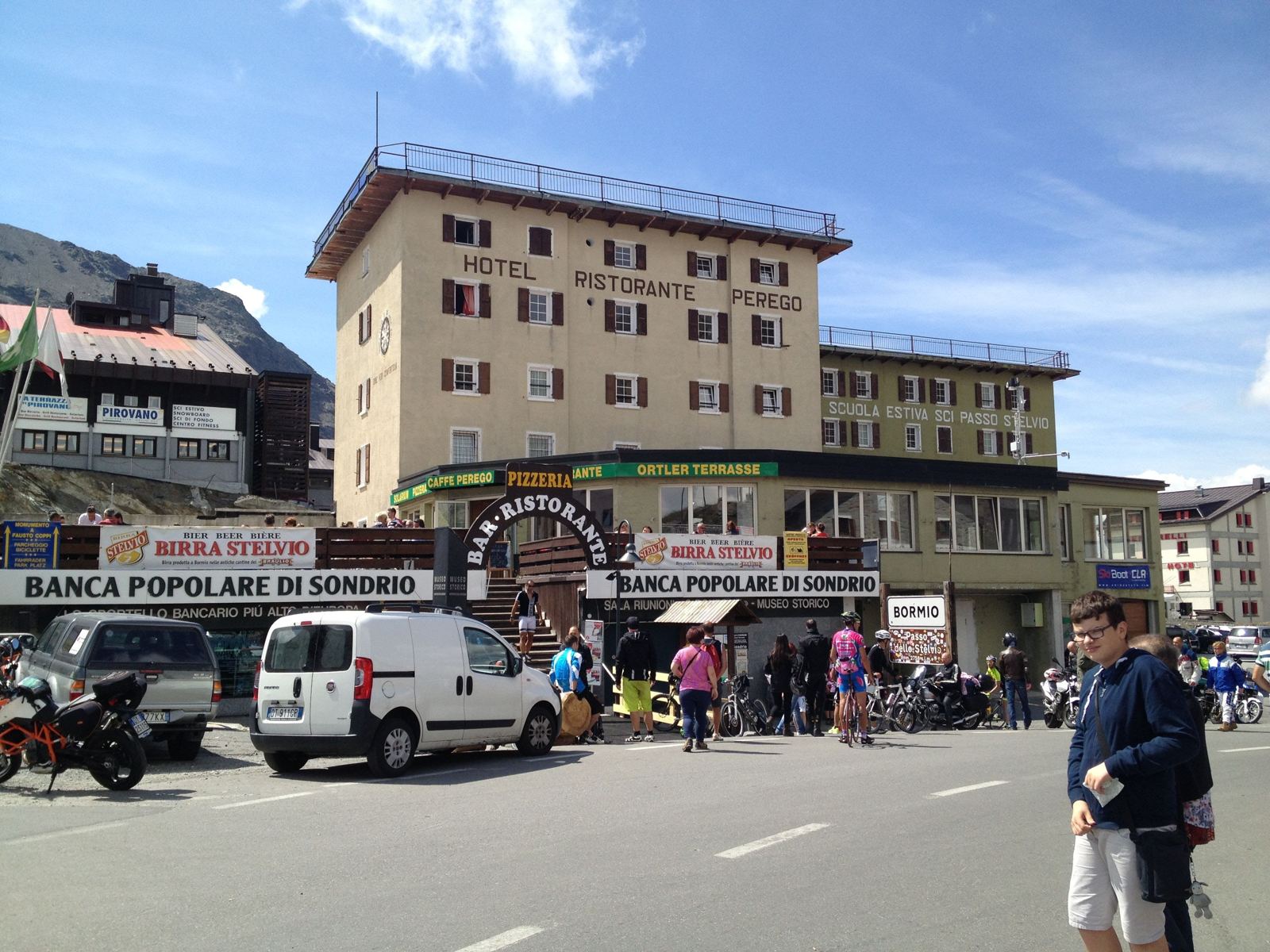 The busy summit of the Stelvio Pass with hotels, stalls, riders and motorbikes