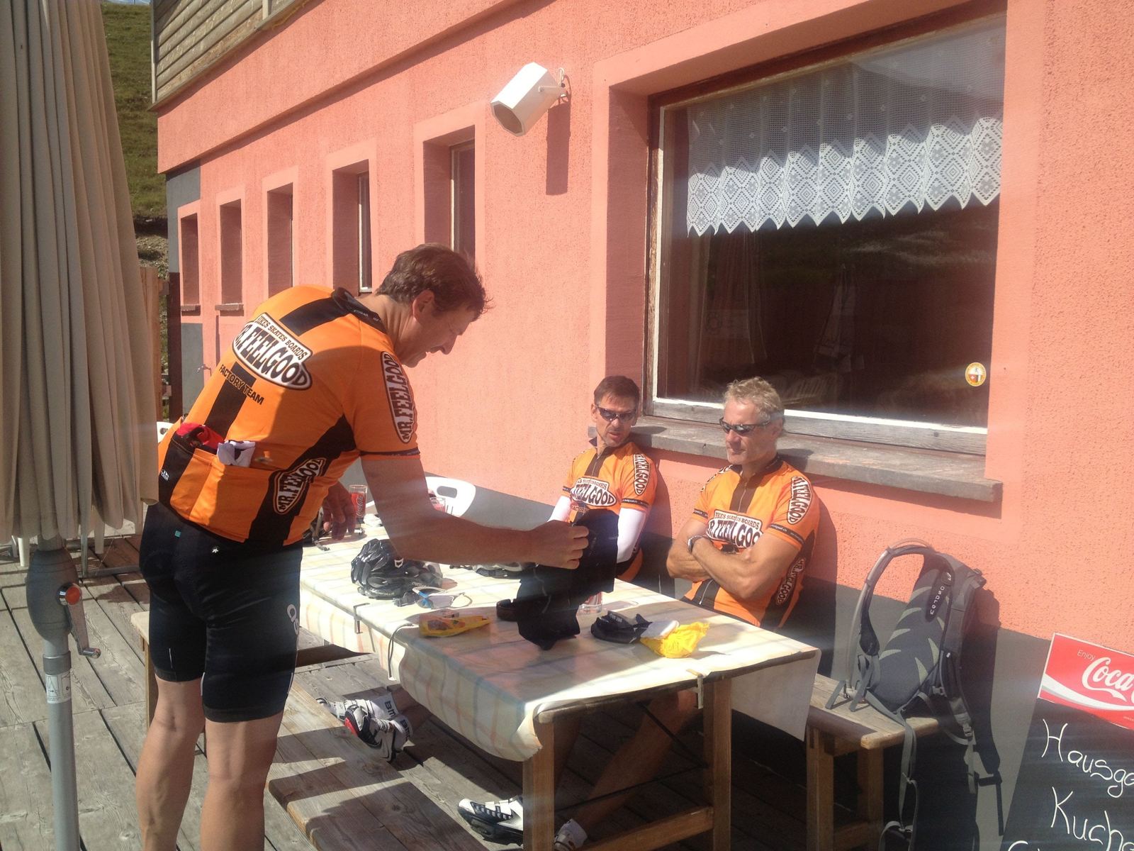 Me and two riding companions in orange Mr Feelgood team jerseys at a cafe table after the ride