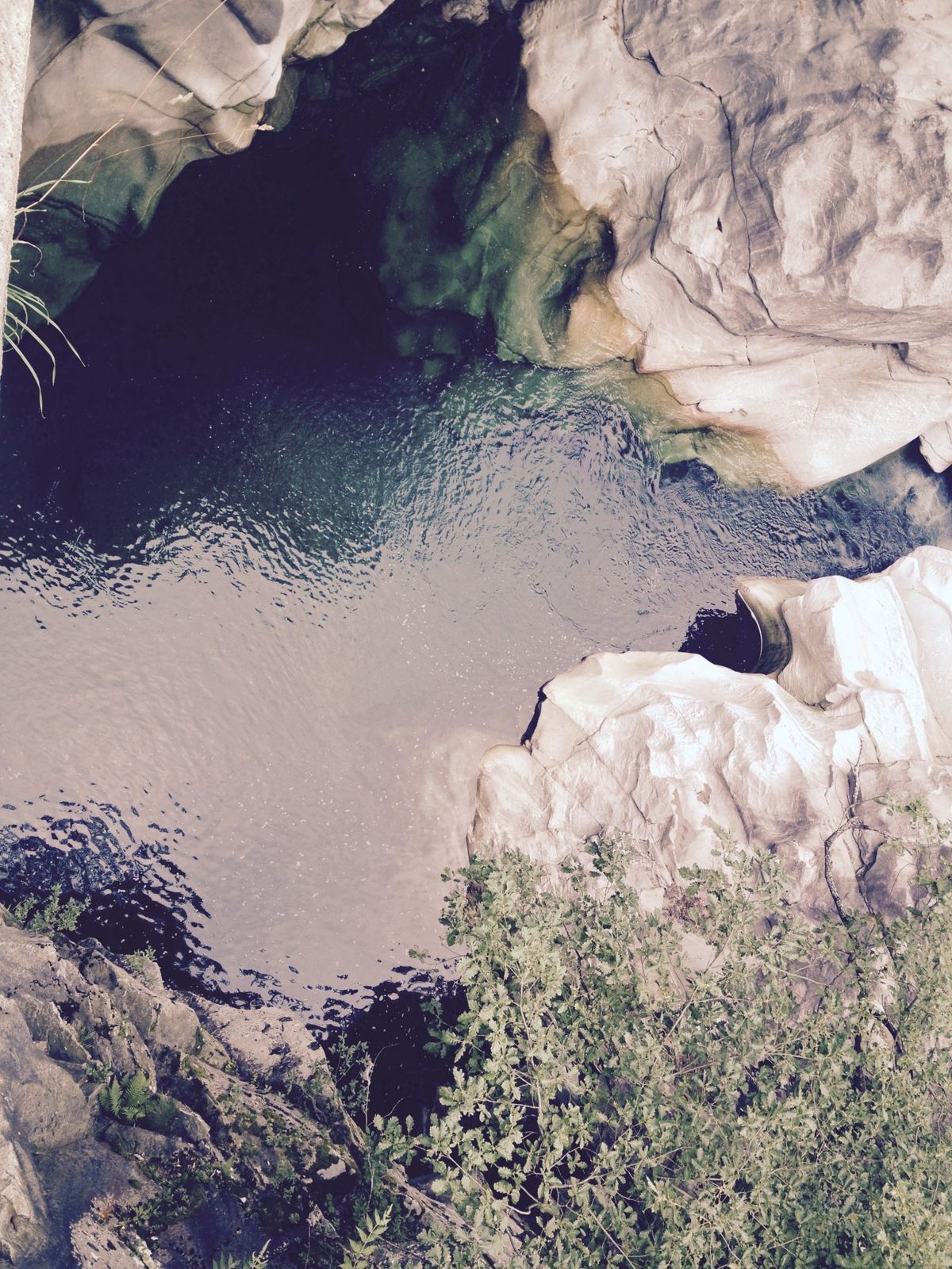 A dark green pool in the river at Lavertezzo, between smooth white rocks